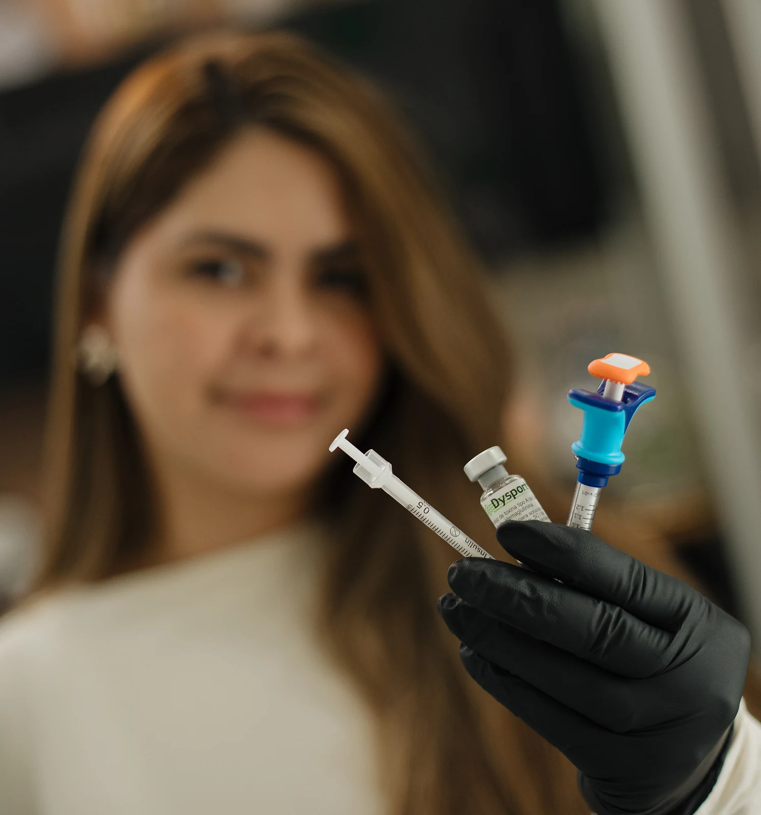 La Dra. Sibaja sosteniendo un vial de Dysport y las jeringas con que lo dosifica